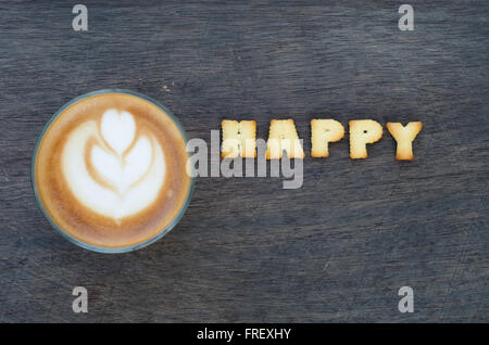 A cup of latte art and alphabet 'happy ' made from bread cookies Stock Photo