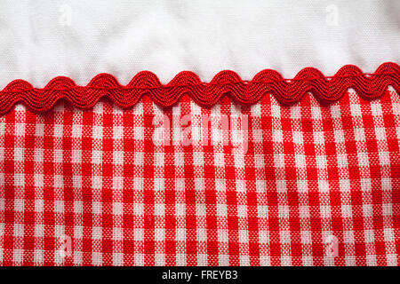 Detail of red checked gingham fabric material and trim on Baby C baby girl's dress Stock Photo