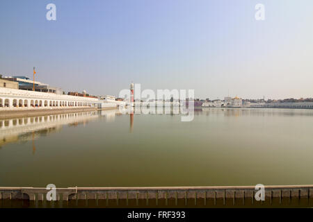 A view across large Sarovar at Tarn Taran Gurdwara in the Punjab, India under a blue sky in springtime Stock Photo