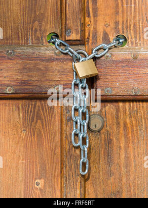 Lock  and shiny rings chain closing a wooden garden  gate Stock Photo