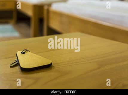 A key of a hotel room is on a wooden table. Selective focus. Stock Photo