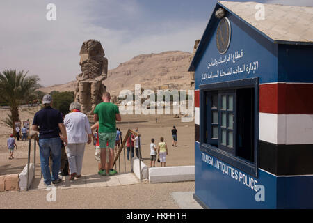 Tourism and antitquities Police hut and tourists at the ancient Egyptian Colossi of Memnon site, Luxor Nile Valley, Egypt. The Colossi of Memnon (memorial temple of Amenophis III) are two massive stone statues of Pharaoh Amenhotep III, who reigned during Dynasty XVIII. For the past 3,400 years (since 1350 BC) they have stood in the Theban necropolis, west of the River Nile from the modern city of Luxor. Stock Photo