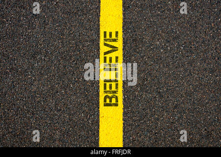 Road marking yellow paint dividing line with word BELIEVE, concept image Stock Photo