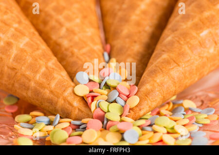Colorful sugar sprinkles and ice cream cones. Preparation for party or celebration. Concept of birthday styling. Stock Photo