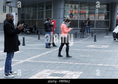 Brussels, Belgium. 22nd Mar, 2016. People check their cellphones as news of the attacks in Brusses spread Credit:  Rey T. Byhre/Alamy Live News Stock Photo