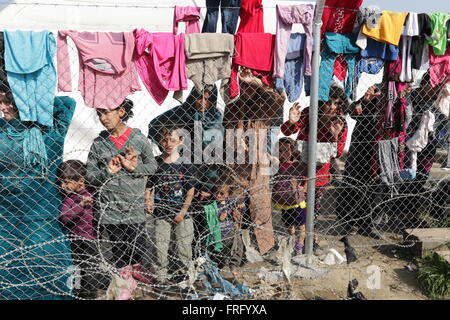 Idomeni, Greece, 22 March 2016. Women and children hold on to a fence at a makeshift camp for refugees and migrants at the Greek Macedonian border, near the village of Idomeni. Credit:  Orhan Tsolak / Alamy Live News Stock Photo
