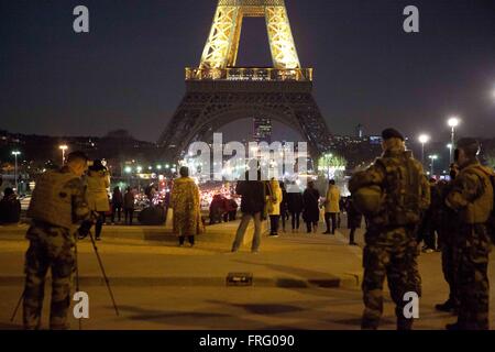 Paris, France. 22nd Mar, 2016. The Eiffel Tower lit up in the colors of the Belgian flag Tuesday night in a show of solidarity following the early morning terrorist attacks in Brussels that killed at least 34 people and injured 250 others. French military soldiers take photos in front of the Eiffel Tower and show solidarity to Belgium,  Paris, France Credit:  Ania Freindorf/Alamy Live News Stock Photo