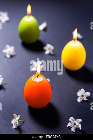 Colored wax candles in the shape of Easter egg with flowers Stock Photo