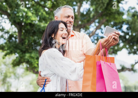 Cheerful couple looking in mobile phone Stock Photo