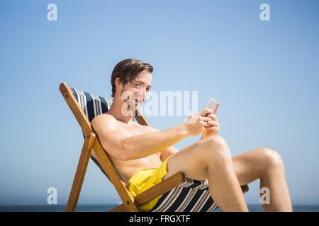 Man relaxing and using smartphone Stock Photo