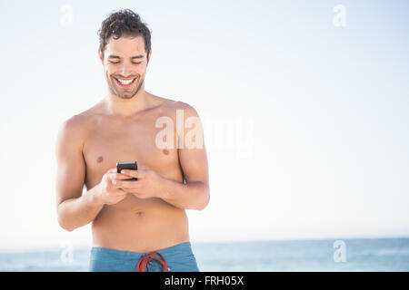 Smiling fit man using smartphone Stock Photo
