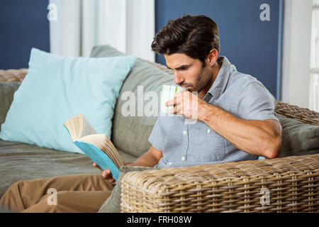 Man having coffee while reading book Stock Photo
