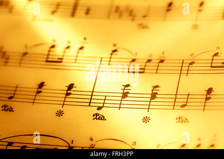 Music notes in yellow toning in closeup Stock Photo