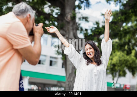 Man photographing woman with arms raised Stock Photo