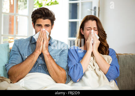 Young couple blowing their nose in tissue Stock Photo