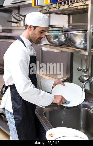 Handsome employee doing dishes Stock Photo