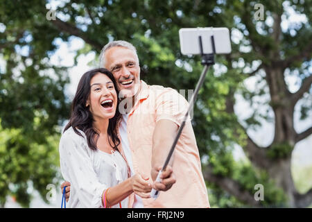 Cheerful couple taking selfie using monopod Stock Photo