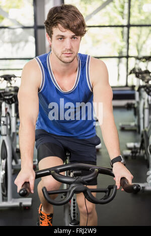 Man working out on exercise bike at spinning class Stock Photo