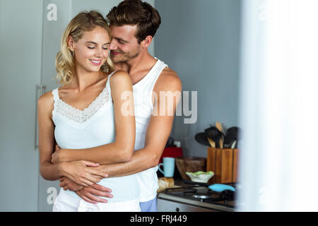 Romantic couple embracing from behind in studio shot, man is