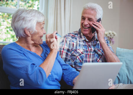 Smiling senior couple using technology Stock Photo