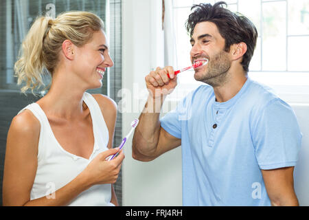 Couple brushing their teeth in bathroom Stock Photo