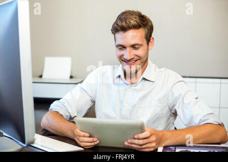Smiling businessman using digital tablet in office Stock Photo