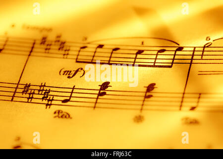 Music notes in yellow toning in closeup Stock Photo