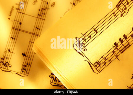 Music notes in yellow toning in closeup Stock Photo