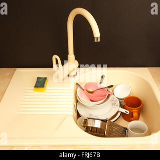 Dirty dishes in kitchen sink in closeup Stock Photo