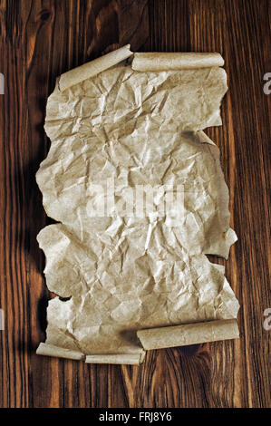 The ancient parchment or unrolled scroll on a wooden background Stock Photo