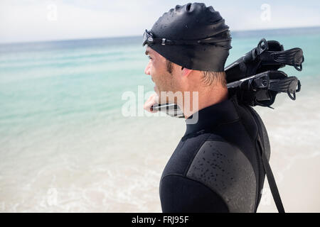 Surfer with flippers standing on the beach Stock Photo