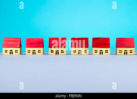 Figurine wooden houses on blue background Stock Photo