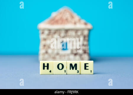 Ceramic house with sign on blue background Stock Photo