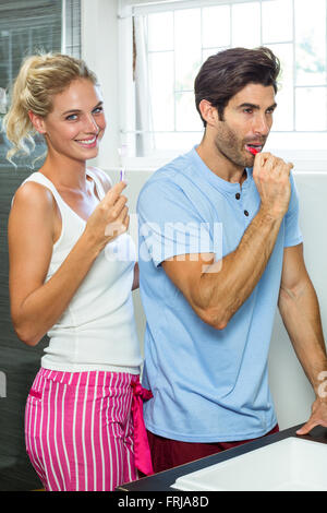 Couple brushing their teeth in bathroom Stock Photo