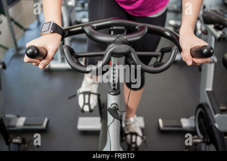 Woman working out on exercise bike at spinning class Stock Photo