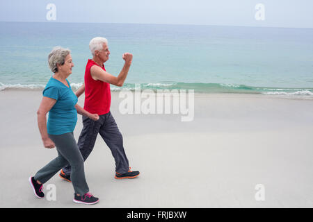 Senior couple jogging on the beach Stock Photo