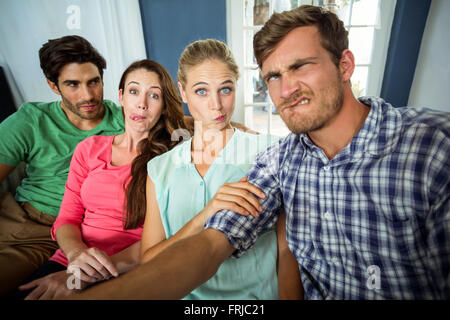 Friends making funny faces at home Stock Photo
