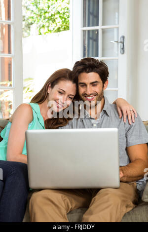 Happy young couple using laptop Stock Photo