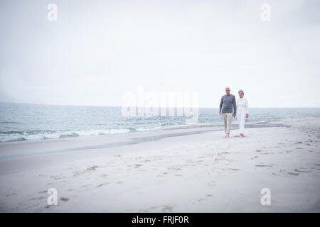 Senior couple walking on the beach Stock Photo