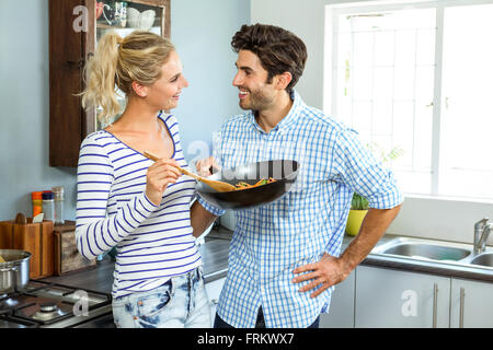 Young couple preparing food together in kitchen Stock Photo