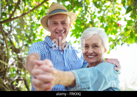 Cheerful retired couple dancing outdoors Stock Photo