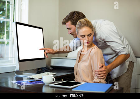 Man touching female colleague while working at office Stock Photo