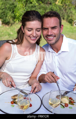 Portrait of man having meal with wife in lawn Stock Photo