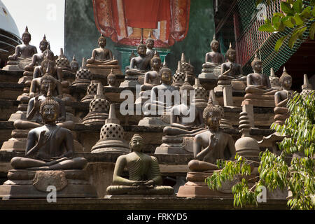 Sri Lanka, Colombo, Gangaramaya Temple, multiple Buddha figures around central dagoba Stock Photo