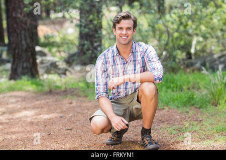 Portrait of young man crouching on field Stock Photo