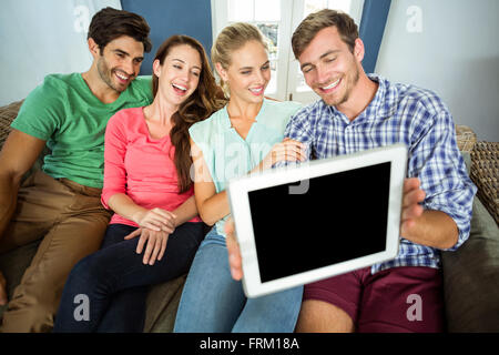 Smiling friends taking selfie through digital tablet Stock Photo