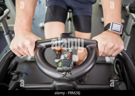 Man working out on exercise bike at spinning class Stock Photo