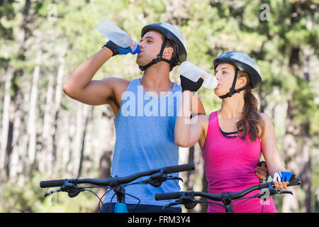 Young couple drinking water at forest Stock Photo