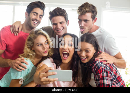 Happy friends making faces while taking selfie at home Stock Photo