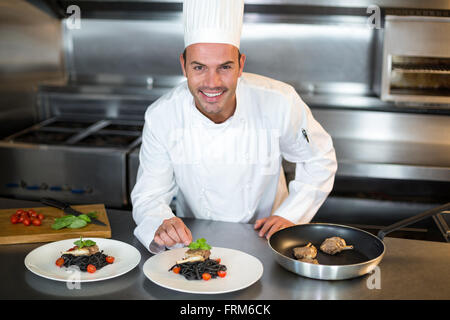 Chef putting finishing touch on dish Stock Photo